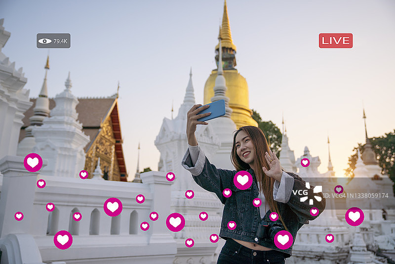 年轻女游客用手机云台录制视频，旅行博主概念图片素材