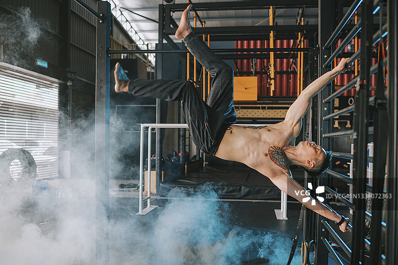 在健身房练习体操的亚洲男子图片素材