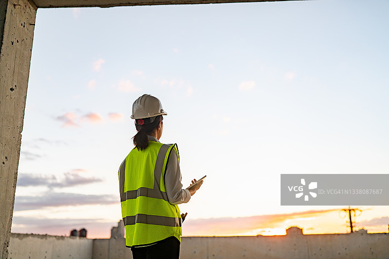 年轻女工程师在建筑工地使用平板电脑图片素材