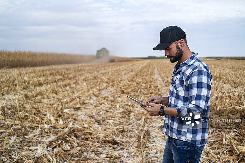 在玉米种植园里的男人。研究员。图片素材