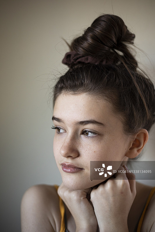 梳着发髻、看向侧面的12岁女孩肖像图片素材
