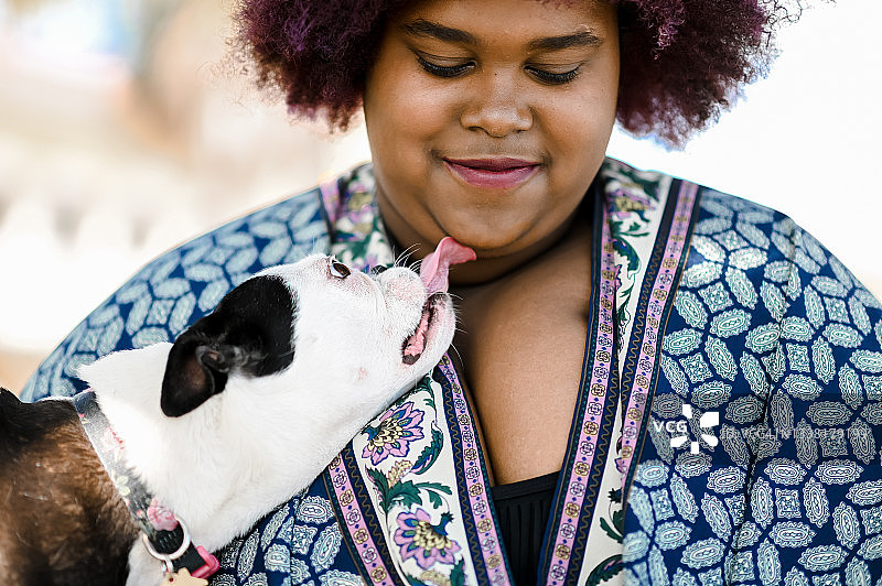 非裔美国女人在户外和可爱的波士顿梗宠物犬一起度过时光图片素材