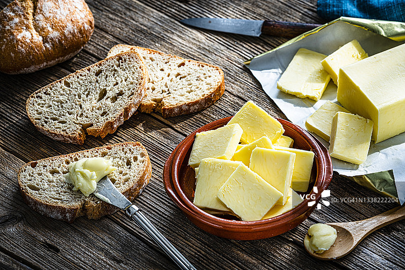 木桌上的黄油片和面包图片素材