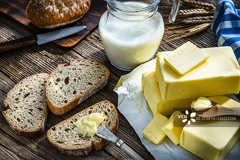 木桌上的黄油牛奶和面包片图片素材