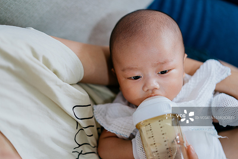 用奶瓶喝牛奶的亚洲婴儿图片素材