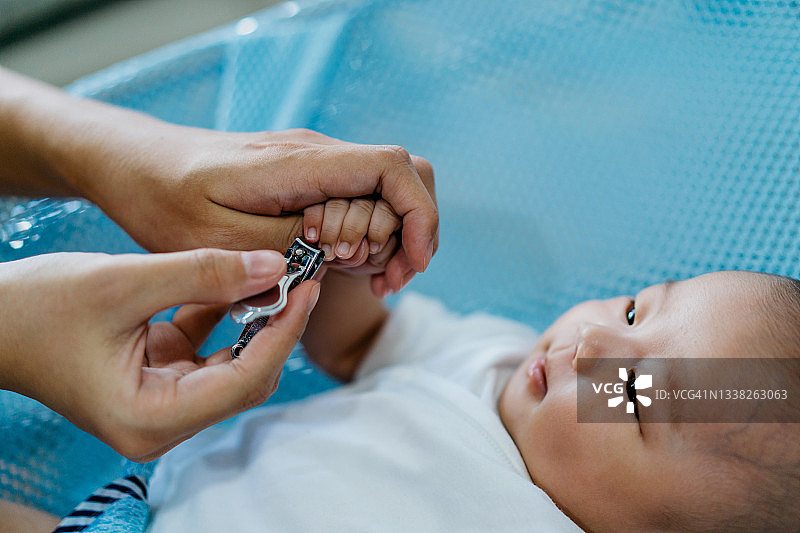母亲在家为宝宝剪指甲图片素材