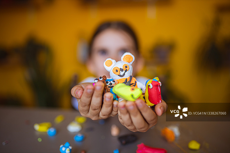 为用儿童橡皮泥创作的艺术品感到自豪的女人图片素材