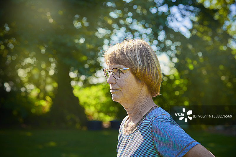 在花园里的退休妇女侧面照图片素材