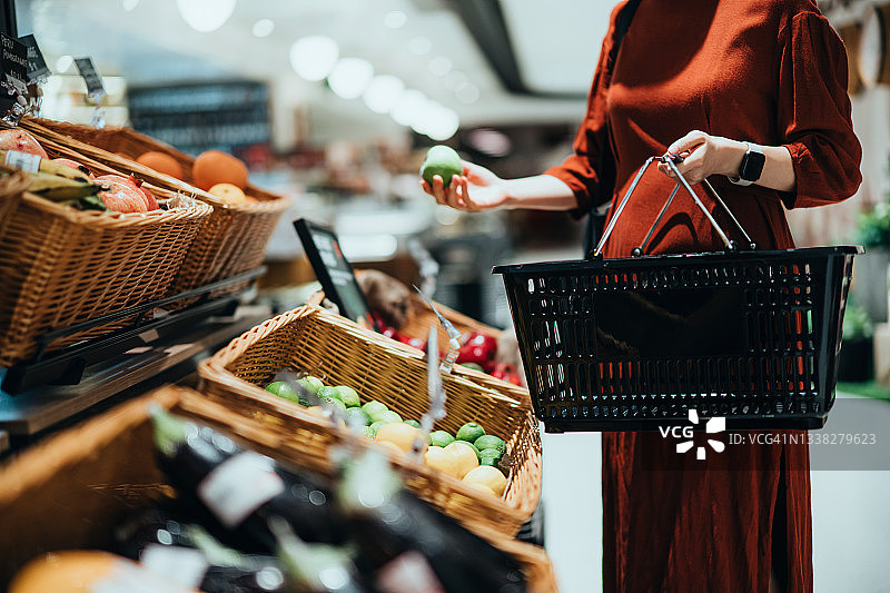年轻亚洲女性在超市购买新鲜有机水果和蔬菜图片素材