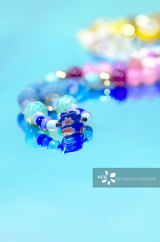 全息箔纸上的彩色串珠饰品和文案空间图片素材