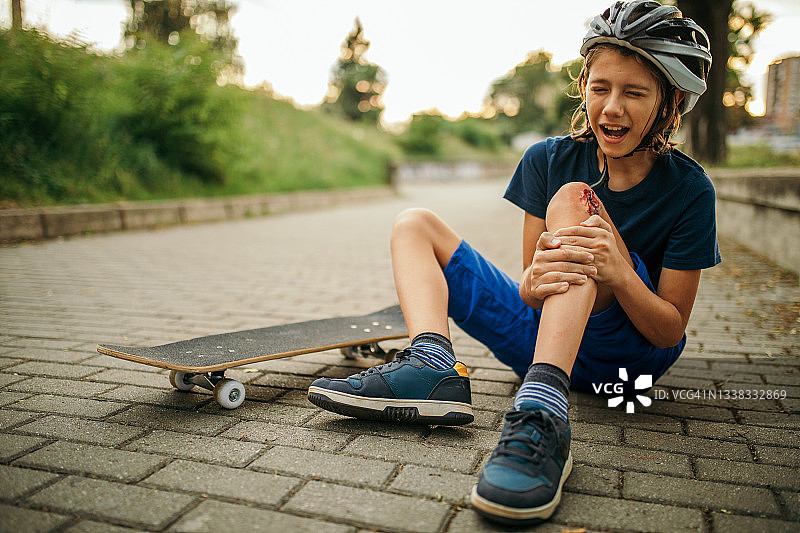 从滑板上摔下来的受伤男孩图片素材