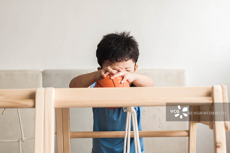 疫情封锁期间，一名东南亚男童在家里的室内游乐场玩耍图片素材