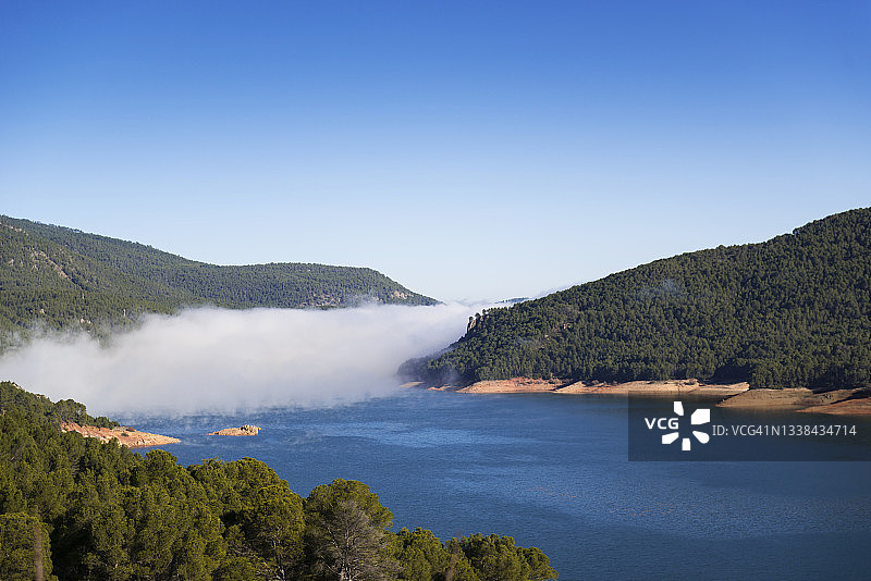 塞古拉山脉贝亚斯河畔埃尔特兰科水库的雾气笼罩的大湖和高山图片素材