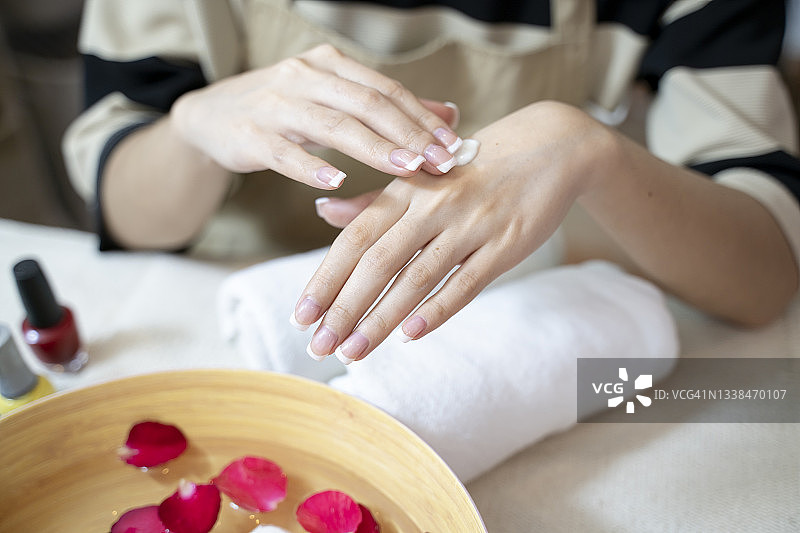 皮肤护理概念：手部使用护手霜的漂亮女人，特写镜头，在柔软的皮肤上涂抹化妆品，美容概念图片素材