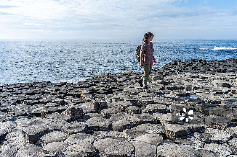 女人在巨人堤游玩，位于英国北爱尔兰安特里姆郡阿尔斯特地区图片素材