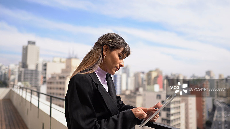 在户外使用平板电脑沉思的年轻女商人图片素材