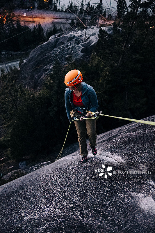 在不列颠哥伦比亚省斯阔米什附近岩壁上绳降的女人图片素材