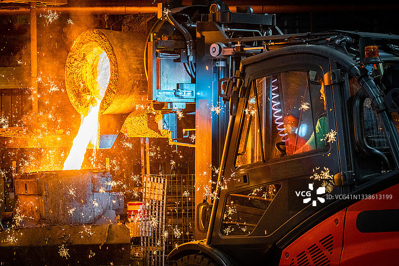 用叉车将液态熔融金属倒入铸造模具中图片素材