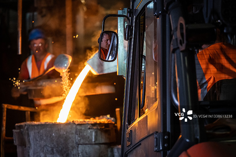 用叉车将液态熔融金属倒入铸造模具中图片素材