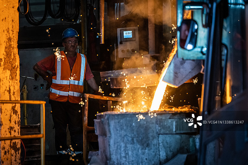 用叉车将液态熔融金属倒入铸造模具中图片素材