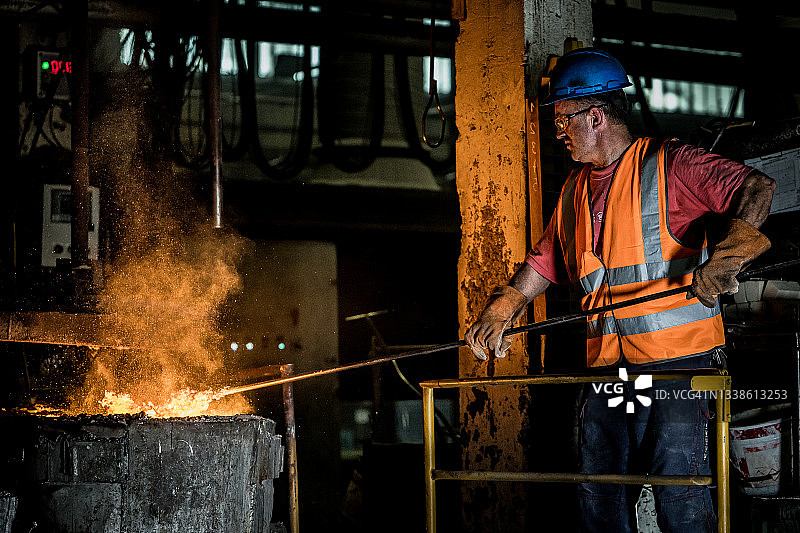 中年男人在钢铁厂检查熔融金属图片素材