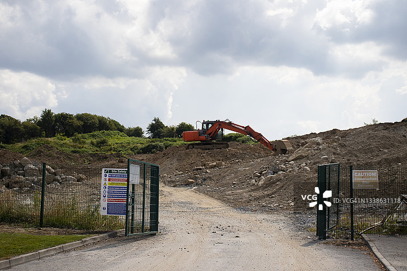 户外建筑工地山顶上的橙色挖掘机图片素材