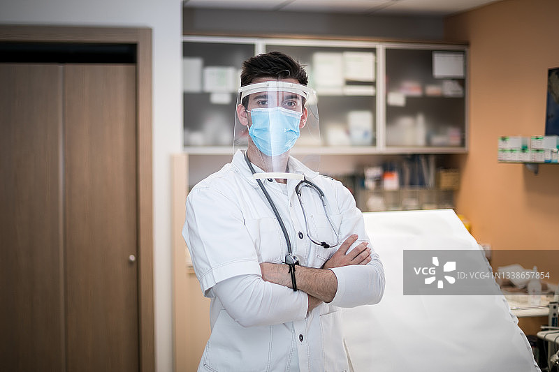 年轻医生身穿制服和防护罩，以防范新型危险病毒COVID-19图片素材