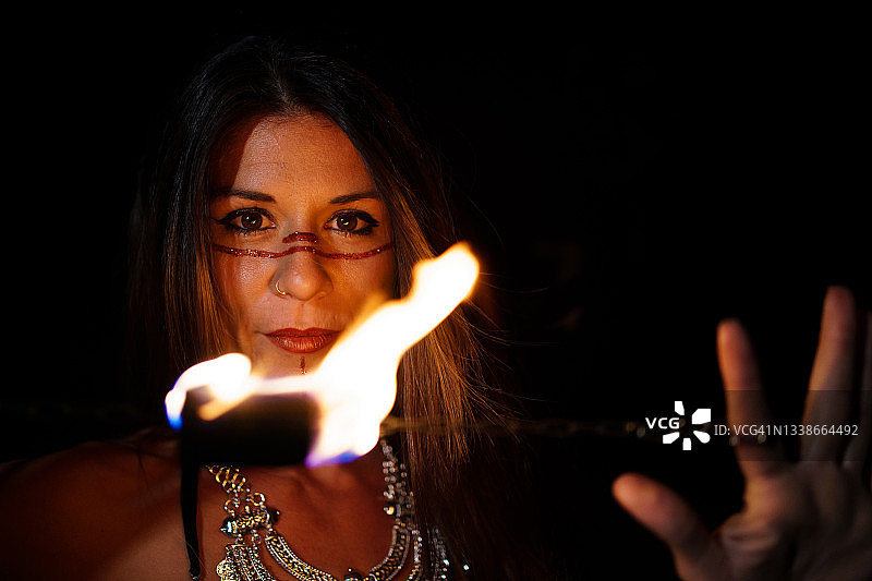 夜晚中带火光的女孩看着镜头图片素材