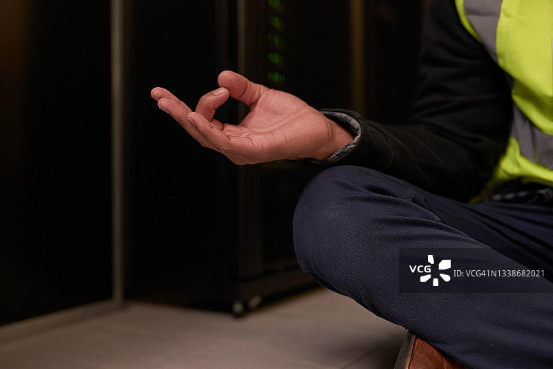 一位难以辨认的男工程师在服务器机房做瑜伽的场景图片素材