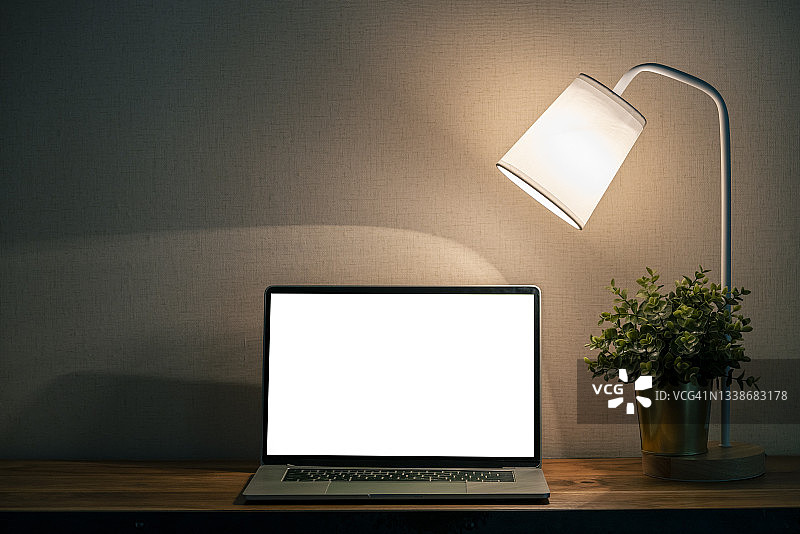 夜晚木桌上的笔记本电脑图片素材