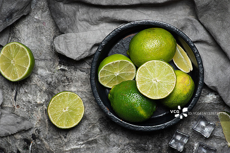 碗中木桌上的新鲜青柠图片素材