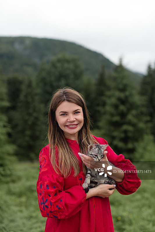 在山里抱着小猫的快乐女人图片素材