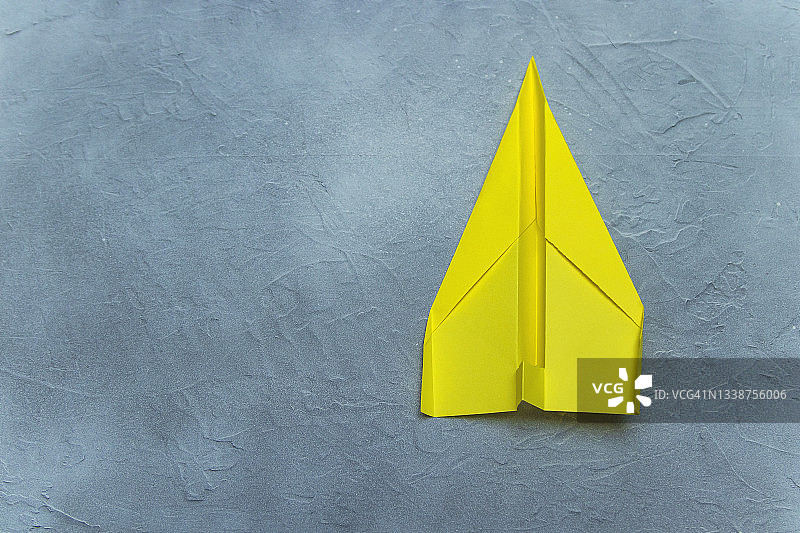 灰色石面上的黄色纸飞机图片素材