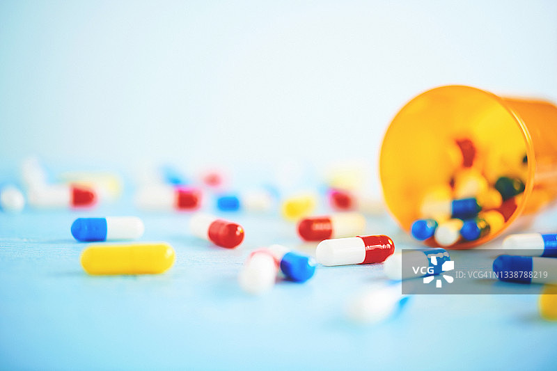 蓝色桌面上放着各种药丸的医疗主题背景图片素材