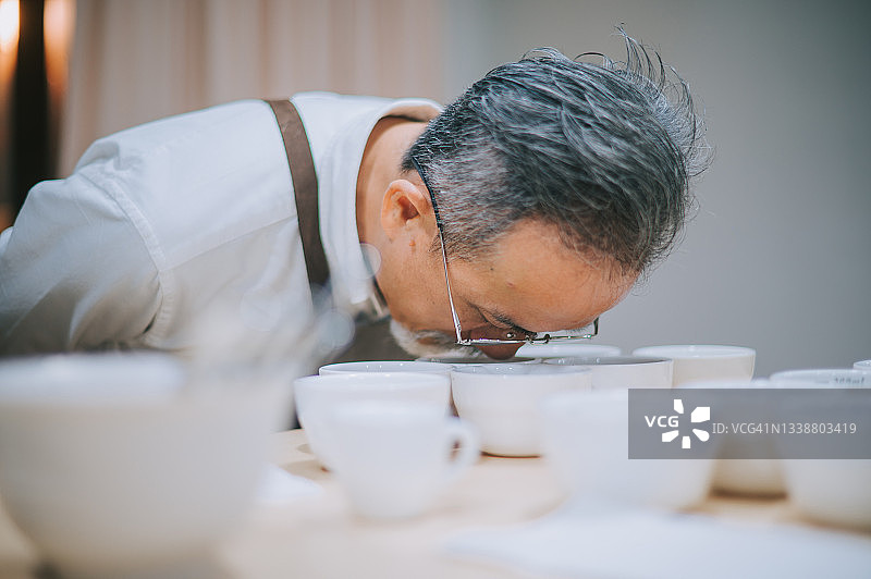 中国老年人在咖啡杯测过程中闻咖啡图片素材
