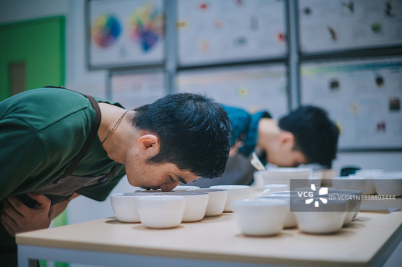 专业亚裔咖啡师正在进行咖啡杯测图片素材