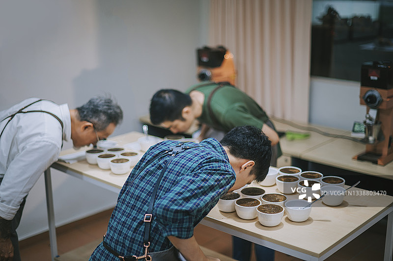 亚裔咖啡师品鉴咖啡豆特写图片素材