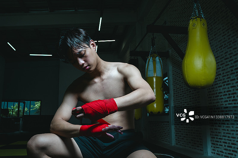 少年拳击手在健身房训练后疲惫图片素材