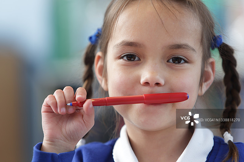 咬笔的年轻女学生图片素材