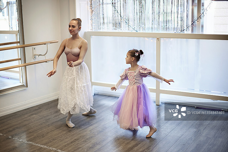 女孩和年轻女子在芭蕾舞工作室跳舞图片素材
