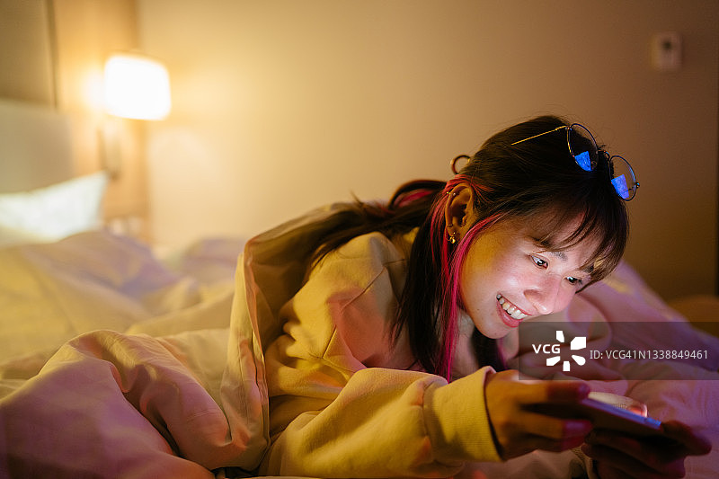 在家手持智能手机的高兴女人图片素材