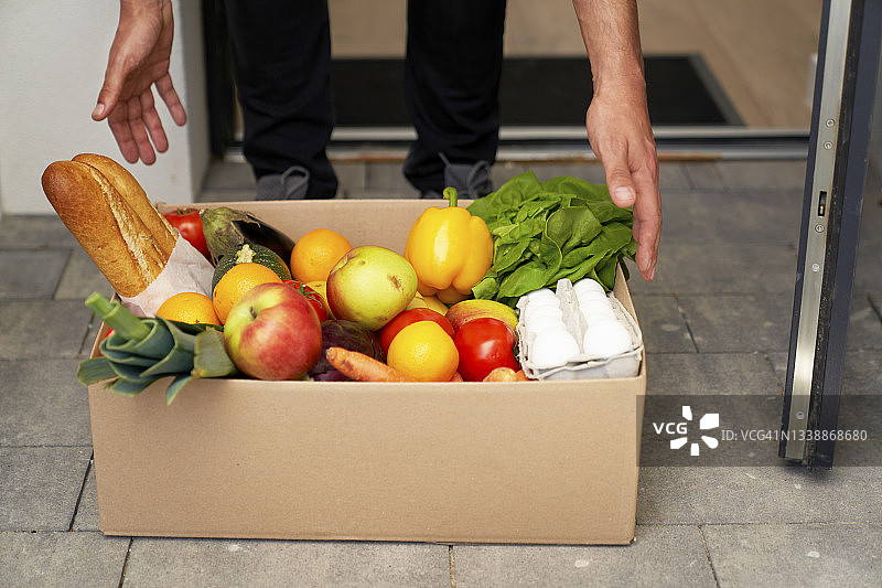 男子在门口接收订购的食品杂货图片素材