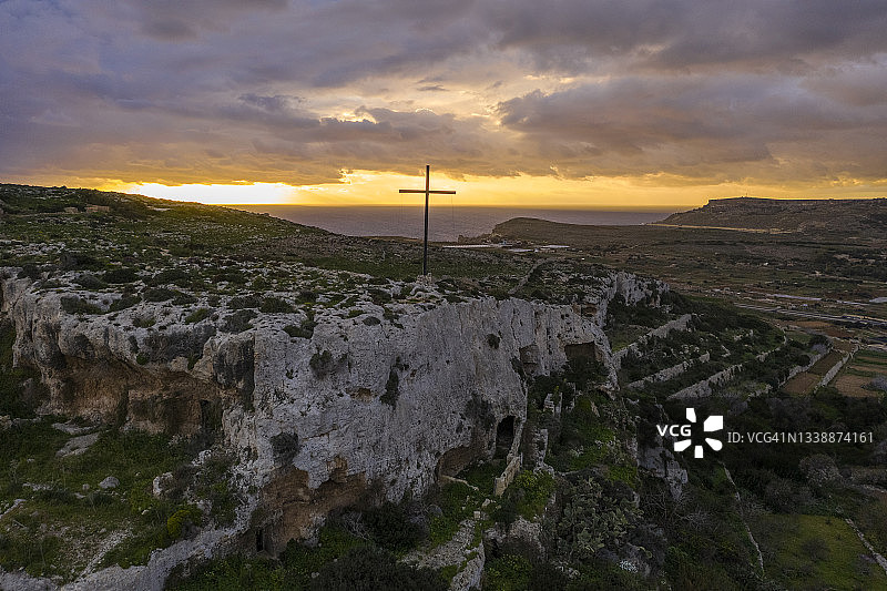 壮丽日落下的山顶十字架图片素材