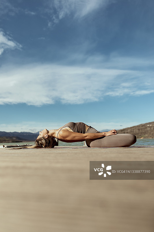 女运动员在码头上做鱼式瑜伽图片素材