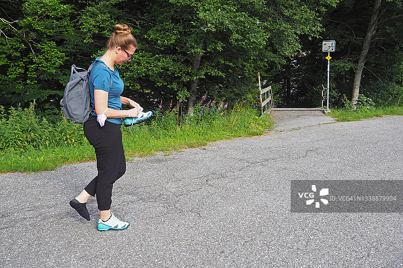 年轻女人脱掉磨脚的鞋子图片素材