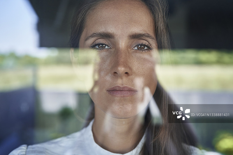 严肃的女人凝视着玻璃图片素材