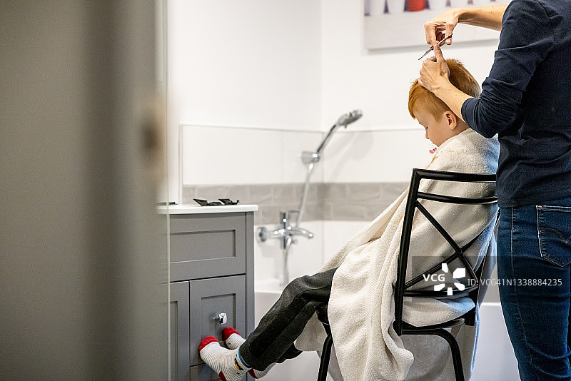 在家理发的可爱红发男孩图片素材