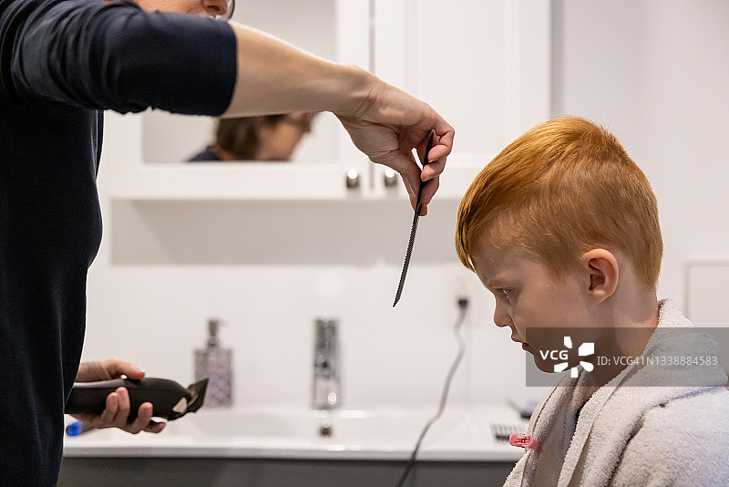 在家理发的可爱红发男孩图片素材