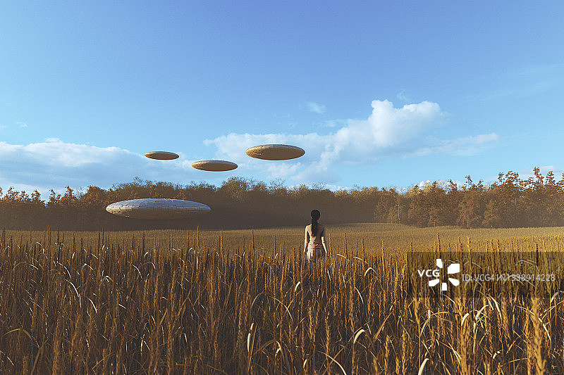 走向麦田里不明飞行物的女人图片素材