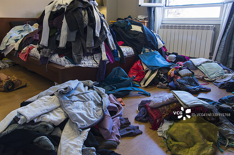 散落在地板和床上的衣服和其他物品图片素材